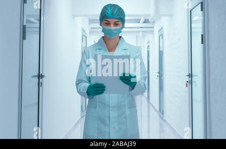 Frau in der medizinischen Verschleiß auf Dokumente Stockfoto
