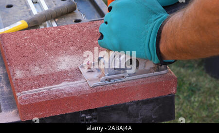 Tile cutter Industrie anlagen. Arbeiter schneiden Bodenplatten für die Verlegung auf der Terrasse mit Kreissäge elektrische Stockfoto