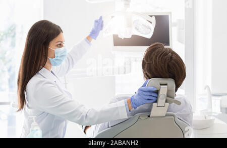 Zahnarzt Arzt Einschalten der Lampe vor Behandlung von Patienten Stockfoto