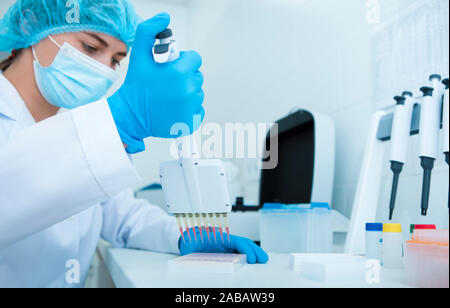 Frau sammeln von Blutproben von der Pipette für die Prüfung Stockfoto