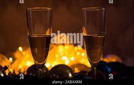 Gläser Champagner auf dem Tisch mit Weihnachten Weihnachten Spielzeug und Girlanden. Neues Jahr und Weihnachten mit Gläser Champagner, Urlaub 2020. Stockfoto