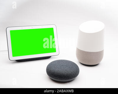 Nov 2019, Großbritannien - Google Home, Nest und USB-Hubs auf Show zusammen mit Green Screen auf weißem Hintergrund Stockfoto