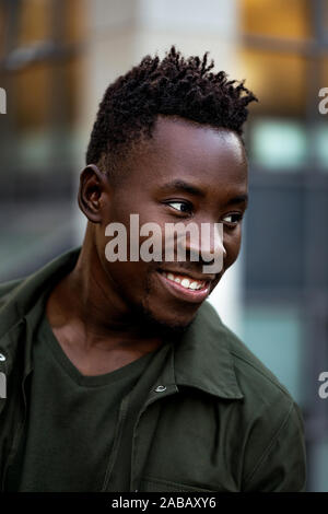 Portrait von afrikanisch-amerikanischen Mann in stilvolle Jacke auf Stadt Straße in den Abend Stockfoto