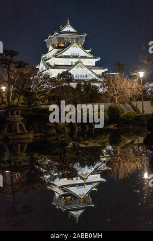 Das Schloss Osaka spiegelte sich nachts in einem Teich in den Gärten wider. Osaka, Japan Stockfoto