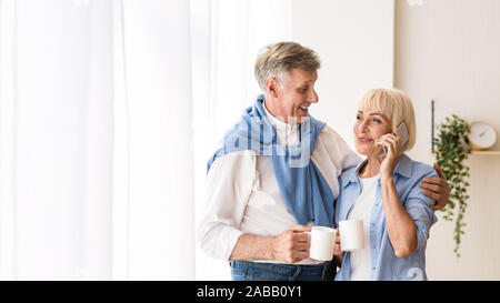Gerne ältere Frau am Telefon sprechen in der Nähe von Fenster, freier Speicherplatz Stockfoto