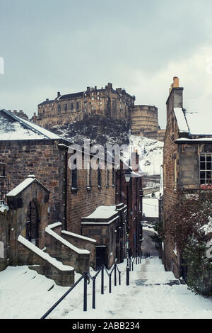 Blick auf die Burg von Edinburgh nach Schnee von der historischen Vennel Schritte am Grassmarket in der Altstadt von Edinburgh, Schottland, Vereinigtes Königreich Stockfoto