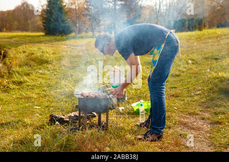 Kochen Grill auf den Grill. Ein Mann kocht Grill Schweinefleisch auf Holzkohle. Stockfoto