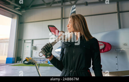 Mädchen Techniker in den Hangar mit dem Flugzeug Stockfoto