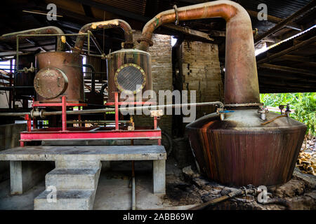 Antoine Risses Rum Distillery, Saint Patrick, Grenada. Unter den Ladeluftkühlern wurde anschließend nur noch eine Betonplattform gebaut. Die Gefäße der Destillationskolonne haben noch die Form aus dem Gründungsjahr 1785 Stockfoto