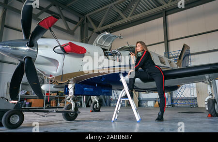 Mädchen Techniker in den Hangar mit dem Flugzeug Stockfoto