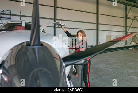 Mädchen Techniker in den Hangar mit dem Flugzeug Stockfoto