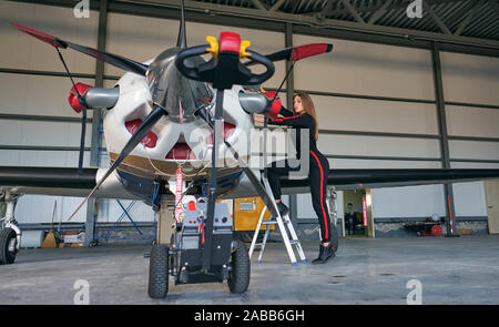 Mädchen Techniker in den Hangar mit dem Flugzeug Stockfoto