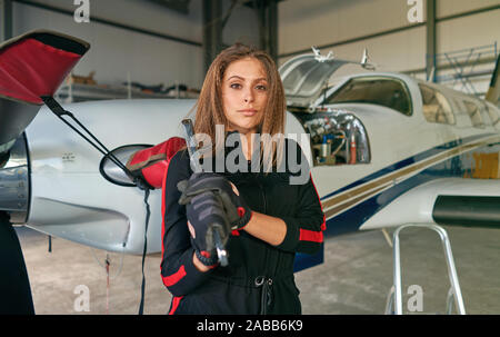 Mädchen Techniker in den Hangar mit dem Flugzeug Stockfoto