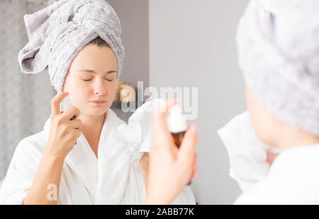 Pflege der Haut. Schöne Frau ist Sprühen micellares Wasser auf das Gesicht. Kosmetik Konzept. Stockfoto