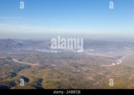 Blick von oben auf einer kurvigen Autobahn Straße durch die Täler und Wälder mit Hintergrund Berge und blauer Himmel Stockfoto