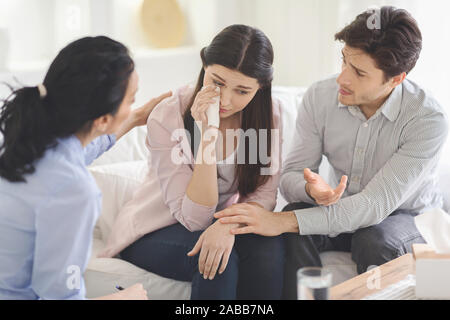 Psychotherapeutin und junger Mann verärgert Frau während der Therapie unterstützen. Stockfoto