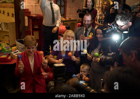 Glasgow, Schottland, 26. November 2019. Nicola Stör, Erster Minister und Leiter der Scottish National Party, auf der Campaign Trail, Met mit Kindern von einem lokalen Kindergarten und wurde von der SNP Kandidat für Lanark & Hamilton Ost, Angela Crawley, und SNP-Kandidat für Airdrie & Shotts, Neil Grau, bei Jollytots & Cookies Café in Larkhall, Glasgow verbunden. Die SNP hat Pläne angekündigt, zu "Transformieren" Elternurlaub in Schottland, Ausweitung der Gemeinsamen verlassen und 64 Wochen mit dem zusätzlichen 12 Wochen ring eingezäunt für den Vater nehmen - bis zu fördern. Quelle: Jeremy Sutton-Hibbert / alamy Leben Nachrichten. Stockfoto