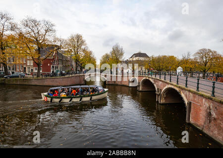 Nacht Blick auf Amsterdam Stadtbild mit Canal, die Brücke und die mittelalterlichen Häuser in der Dämmerung beleuchtet. Amsterdam, Niederlande Stockfoto