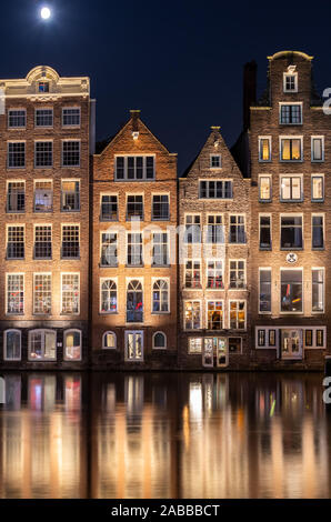 Traditionelle holländische Gebäude am Damrak bei Nacht, Amsterdam, Niederlande Stockfoto