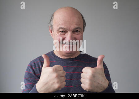 Reifen Hispanic glatzköpfige Mann lächelnd mit Daumen bis zur Genehmigung ihrer Wahl oder Beratung. Positive facial menschliches Gefühl. Stockfoto