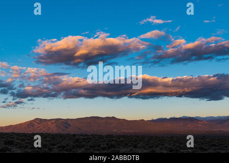 Schönen Sonnenuntergang und bunten Wolken über dem hohen Wüstenlandschaft und Sangre de Cristo Bergkette in der Nähe von Taos, New Mexico, USA Stockfoto