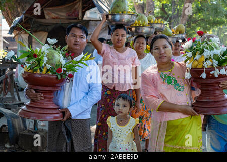 Eine traditionelle Hochzeit Prozession in ländlichen Myanmar (Birma) entlang der Chindwin Fluss mit Familie und Gäste ausrichten mit Geschenken der Früchte und Blumen Stockfoto