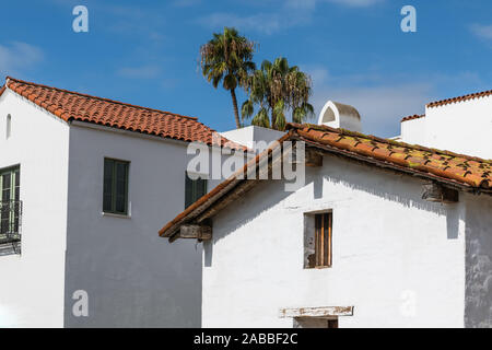 Neue und alte Gebäude im spanischen Stil mit weiß verputzten Wänden und roten Ziegeldächern unter einem blauen Himmel mit Palmen in der Innenstadt von Santa Barbara, Kalifornien Stockfoto