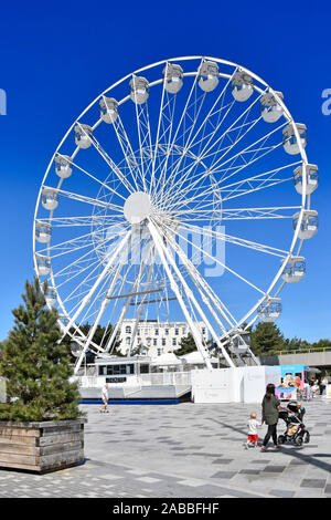 Blue Sky Sommer Urlaub & Seaside Resort Fußgängerzone & große Rad fahren auf Pier Ansatz Mama mit Kinderwagen und Kleinkind Bournemouth Dorset England UK Stockfoto