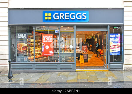 Greggs Sandwiches Pies Gebäck & Bäckerei Lebensmittelgeschäft Kunden und Tische drinnen, draußen bei Regen im Freien in Durham, England Stockfoto