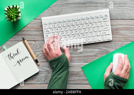 Grün zu Denken, null Abfall creative Flach. Ansicht von oben mit der Hände schreiben auf Tastatur und Maus. Notebook mit Motivation Text öffnen, Mini Stockfoto