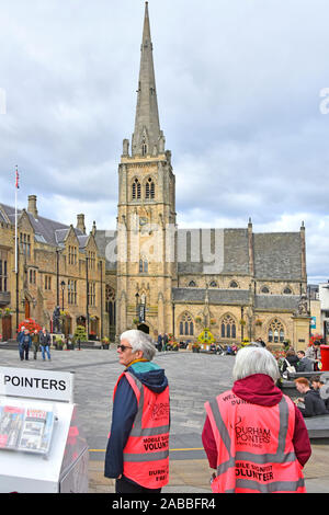 Stadt Durham freiwillige Zeiger Bürger mit lokalem Wissen Hilfe & Informationen für Touristen Kirche jenseits Marktplatz Durham England UK bieten Stockfoto