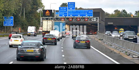 Autobahn M25: Verkehrslärm auf der Autobahn und zahlreiche Schilder am vierspurigen Eingang des Bell Common Tunnel mit variablem 40 km/h-Geschwindigkeitsschild Essex England UK Stockfoto