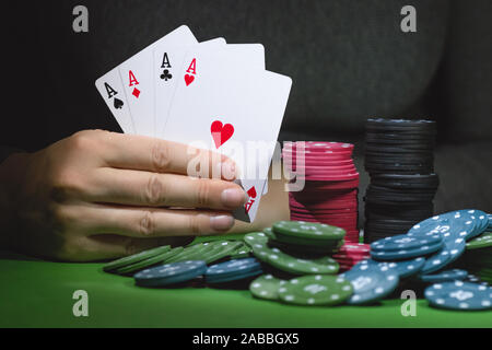 Poker chips auf den Tisch und eine weibliche Hand mit vier Asse schließen oben. Stockfoto