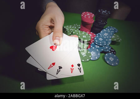 Poker chips auf den Tisch und eine weibliche Hand mit vier Asse schließen oben. Stockfoto