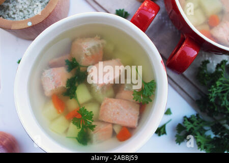 Lachs Suppentassen mit Kartoffeln und Karotten auf weißem Hintergrund, in der Nähe Stockfoto