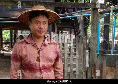 Ein reifer Mann steht außerhalb seines Hauses tragen eine Bernsteinkette in einem ländlichen Dorf im Nordwesten Myanmar (Birma) entlang der Chindwin Fluss Stockfoto