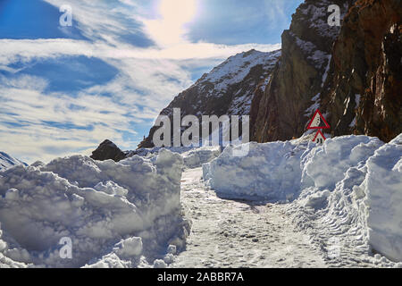 Schmalen Pfad im Schnee bis hoch auf Transfagarasan Straße, Rumänien, im Winter, mit Schildern fast im Schnee begraben. Stockfoto