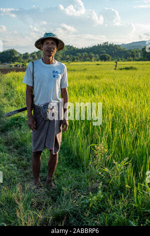 Burmesischen Bauern in konischer Asiatischen Reis Hut kehrt in das Dorf von seinem reisfelder entlang der Chindwin Fluss im Nordwesten Myanmar (Birma) Stockfoto