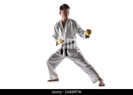 Zuversichtlich koreanischen Mann im Kimono üben Hand-auf-Hand zu bekämpfen, Kampfsportarten Junge männliche Kämpfer mit Black Belt Ausbildung auf weißem studio Hintergrund isoliert. Konzept der gesunden Lebensstil, Sport. Stockfoto