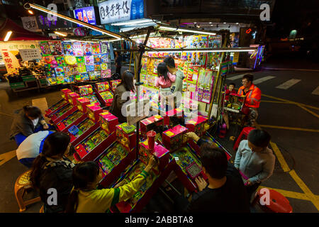 Taoyuan, Taiwan - 12. November 2019: Eine Gruppe junger Leute in Taiwan spielen an einem Spiel stall in Zhongli Nachtmarkt in Taoyuan, Taiwa entfernt Stockfoto