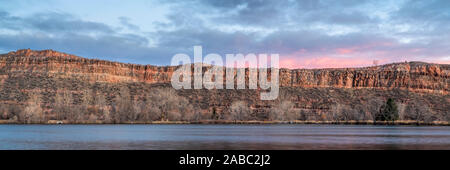 Ruhe Dämmerung über Sandsteinfelsen und einem See am Fuße der Rocky Mountains im Norden von Colorado, Ende Herbst Landschaft Stockfoto