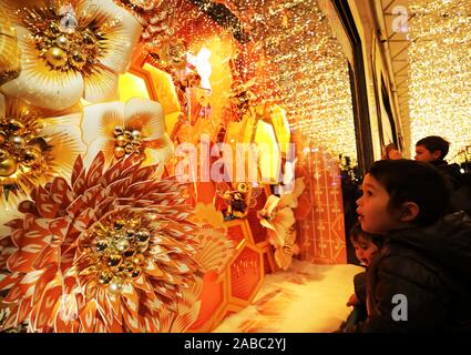 Paris, Frankreich. 24 Nov, 2019. Kinder genießen die Weihnachten Fenster im Kaufhaus Galeries Lafayette in Paris, Frankreich, November 24, 2019. Die Stadt Paris ist mit Weihnachtsbäumen und Dekorationen für die Festival Saison dekoriert. Credit: Gao Jing/Xinhua/Alamy leben Nachrichten Stockfoto