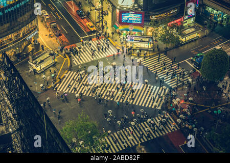 Tokio - 17. APRIL 2017: Shibuya scramble Crossing, einer der belebtesten Fußgängerüberweg in der Welt, Japan. Menschen Überqueren der Straße an regnerischen Tag Stockfoto