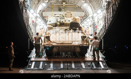 Us-Flieger zum 386. Expeditionary Logistik Bereitschaft Squadron Gespräch mit einem US-Armee Soldat, der eine U.S. Army M2 Bradley Fighting Fahrzeug auf eine US Air Force C-17 Globemaster III im Ali Al Salem Air Base, Kuwait, Okt. 30, 2019 zugeordnet. Flieger und Soldaten die koordinierten Anstrengungen der BFV innerhalb des US Central Command Theater der Operationen für den Transport in die laufenden Bemühungen innerhalb der Region zu unterstützen. (U.S. Air Force Foto von Kapitän Thomas Barger) Stockfoto