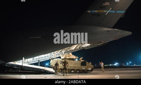 Us-Flieger zum 386. Expeditionary Logistik Bereitschaft Squadron Help Guide ein Soldat der US-Armee das Laden einer M2 Bradley Fighting Fahrzeug auf eine US Air Force C-17 Globemaster III im Ali Al Salem Air Base, Kuwait, Okt. 30, 2019 zugeordnet. Flieger und Soldaten die koordinierten Anstrengungen der BFV innerhalb des US Central Command Theater der Operationen für den Transport in die laufenden Bemühungen innerhalb der Region zu unterstützen. (U.S. Air Force Foto von Kapitän Thomas Barger) Stockfoto