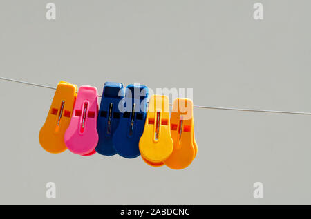 Close Up bunte Wäscheklammern aus Kunststoff für hängende Kleidung auf Eierschalen Farbe Hintergrund Stockfoto