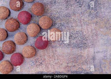 Hausgemachte Raw Vegan Cacao Energie Kugeln liegen auf einer Reihe auf grauem Marmor Hintergrund Stockfoto