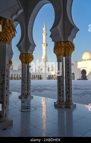 Wunderschöne goldene Säulen entlang der Abu Dhabi Grand Mosque. Stockfoto