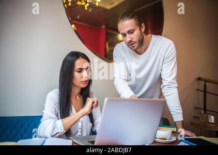 Der bärtige Mann helfen Frau mit der Berechnung der Ausgaben Stockfoto