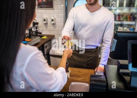 Geschäftsfrau kaufen Kaffee am Morgen und das Zahlen per Karte Stockfoto